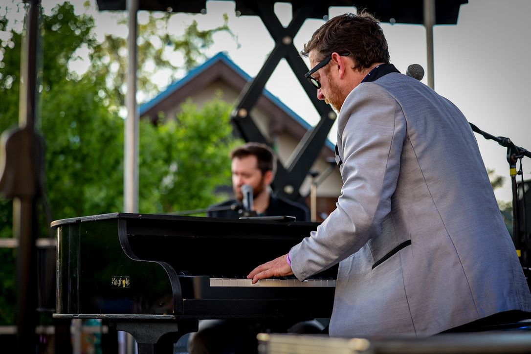 Two musicians performing dueling pianos